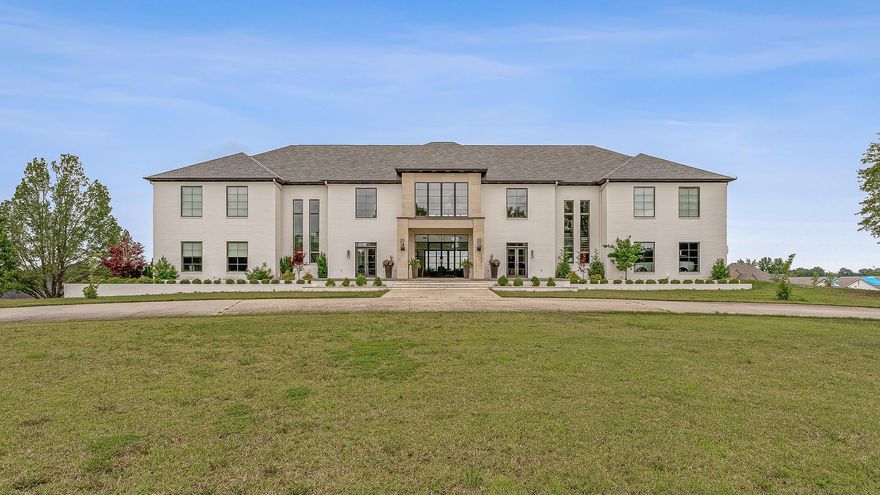 A showcase of modern elegance, this 6-bed, 7.5-bath contemporary estate offering three floors of luxury living on 12.3 acres across from Paragould Country Club golf course. Designed with sophistication and comfort in mind, the home features soaring ceilings, Control4 automation, and an indoor half-court basketball court with full bath. The main level stuns with a Thermador and Sub-Zero chef’s kitchen, gas range, double ovens, two dishwashers, and a scullery with warming drawer, microwave drawer, and extra refrigeration. A wet bar with Sub-Zero wine fridge and cooler drawers enhances entertaining. The theatre room includes a private kitchenette. The primary suite is a retreat of its own, with radiant heat flooring, steam shower, a see-through fireplace, and a backlit onyx feature wall behind the soaking tub. Downstairs, enjoy a spacious family room, home gym, full bath, sauna-ready space, and a secure safe room with a Brown Safe Company vault door. Outdoor amenities include a heated gunite pool with spillover spa, screened firepit lounge, outdoor kitchen with fireplace, and upper-level patios.
