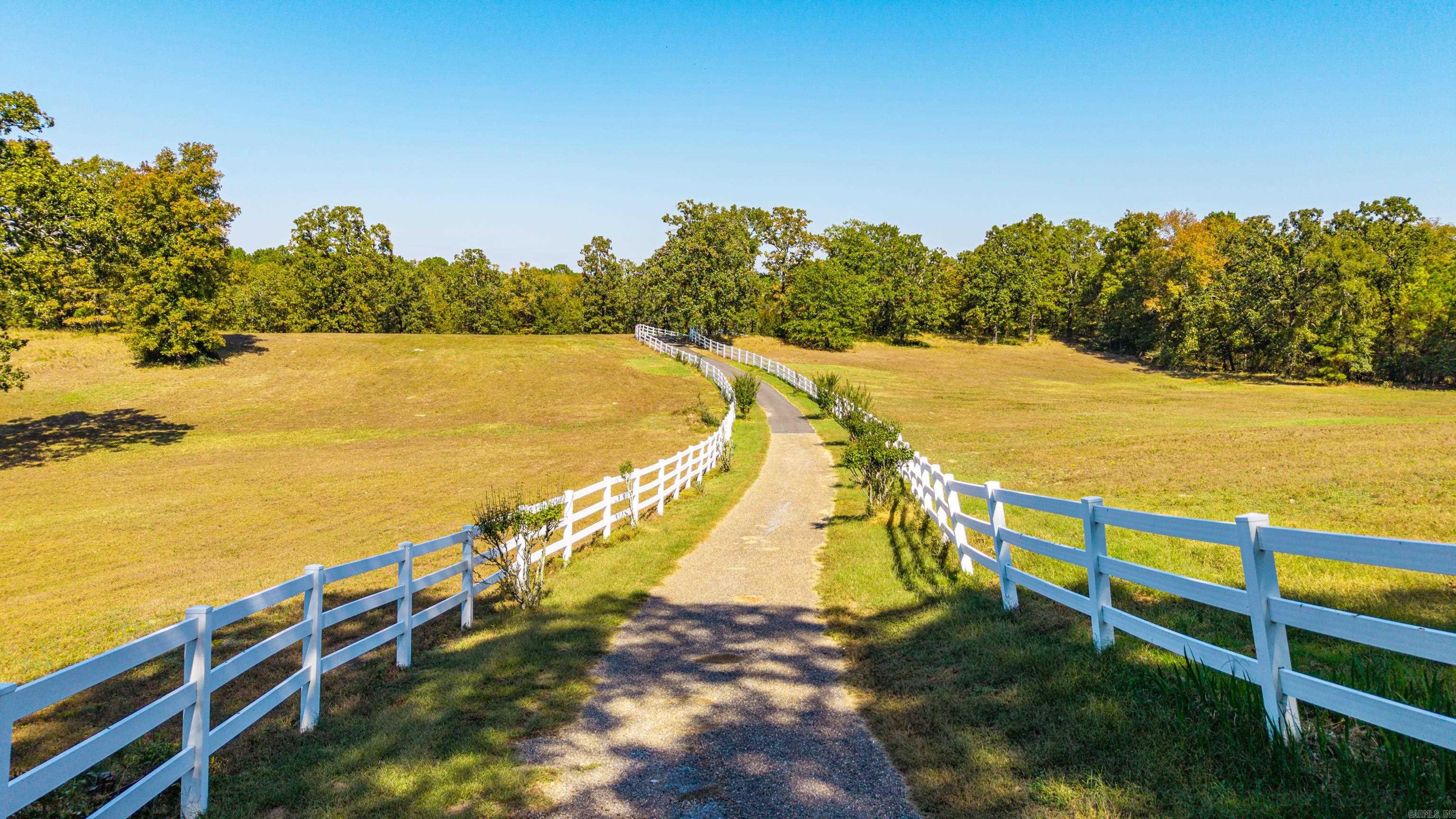 20+ FENCED ACRES, A LOVELY HOME, POOL, SHOP, BARN AND RECREATION ROOM - all less than 10 Minutes to city limits!  The driveway to this property is 1/2 mile long in an extremely private setting!  Come and enjoy the view from the wrap around porches and watch wildlife, horses and evening sunsets!  Interior of the main home offers a large Living Area with crafted millwork, Anderson windows for views of the Pool in the summer and for the Winter - a cozy fireplace.  Other features include hardwood & tile flooring throughout, separate formal and casual Dining, Office/Piano Room, large main level Master Suite, and a great Kitchen and Laundry area. Included with the main home is a separate 1 Bedroom, handicap accessible Apartment with it's own entrance, kitchenette, bath and WI closet! There is also the 850 SF Rec Room - which has its own heat/air, hardwood flooring and can be used for multiple purposes - Pickle Ball, Dance, Family Gatherings, etc.  Beyond the Rec Room is a large shop with 12' overhead doors and a 5 stall horse barn w/ Loft and Tac room.