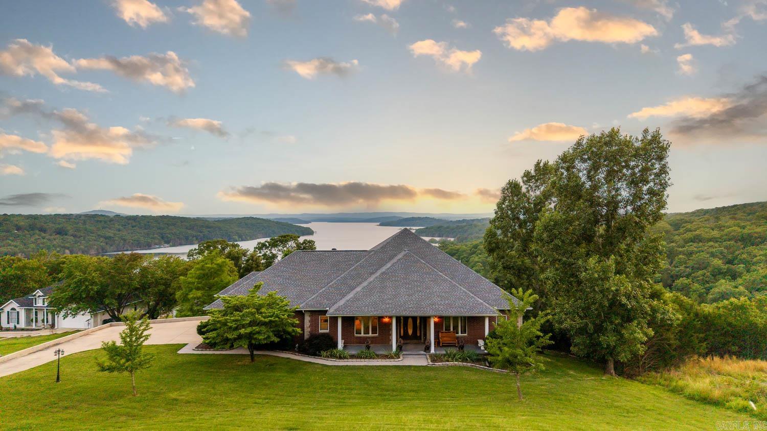 Welcome to your lakeside retreat on Bull Shoals Lake in Mountain Home, Arkansas! This spacious 4-bed, 3.5-bath home includes a bonus room that can serve as a 5th bedroom, plus two full kitchens and living areas—ideal for multi-gen living or hosting. Enjoy panoramic lake views from nearly every room and step onto a freshly repainted deck (2024). A cut trail leads directly to the lake for rare, easy access. Outdoor features include a new pergola, firepit (2024), storage building, and security cameras. Recent updates: new roof (2023), lighting, ceiling fans, fresh paint, new oven and flooring in the downstairs kitchen, new utility sink basins, extra freezer, and upgraded well tank (2024). Fiber optic internet and upgraded septic cleanouts add convenience. Relax in the 2023 Cameo 880 hot tub or enjoy the included pool table, ping pong, shuffleboard, and arcade games. All mattresses were replaced in 2022, and the master has an adjustable king bed. Fully furnished—just bring your suitcase! Perfect for full-time living, vacationing, or investment—this move-in-ready lake home is a must-see!