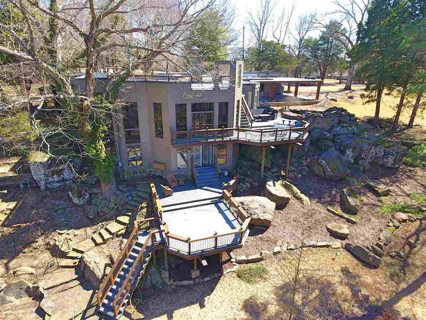 Eden Isle classic adjoining Red Apple Golf Course.  Immaculately kept post mid-century built into a natural rock ledge.  Amazing outdoor spaces with a huge backyard that is your private park.  Slate floors, windows let nature in while providing lots of privacy.  2 br suite separate from main living area.  Downstairs suite is built into the stone ledge with the shower in a cave.  Numerous updates & improvements.  Minutes by cart to Eden Isle Marina and Greers Ferry Lake.  Fully furnished.  AGENTS SEE REMARKS