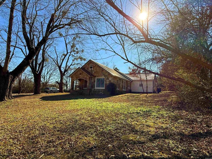Cozy rock cottage vibes with loads of character and warmth!  Step inside to a spacious living room accented by rich wood-tone ceilings and inviting living spaces throughout. This 3-bedroom, 2-bath home offers two large living areas, a massive sunroom perfect for relaxing or entertaining, and a dedicated laundry/storage room for added functionality.    Outside, you’ll find two storage buildings and a double carport, providing plenty of space for vehicles, tools, or hobbies. Major updates include a new roof, HVAC system, and tankless gas water heater—all within the last five years, offering peace of mind for years to come.    Located just minutes outside city limits, this home delivers the perfect blend of convenience, comfort, and country-style charm.