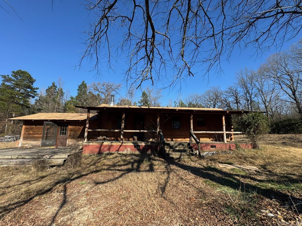 This 3-bedroom, 2-bathroom log cabin in Bauxite is located within the Bauxite School District, offering a private retreat on 4.8 acres. Set back in the woods with a circle drive, the property also includes an extra house, both of which are in need of work but present great potential. The peaceful, wooded surroundings provide a serene setting, while the additional house offers extra space and opportunity. Perfect for someone looking for privacy, land, and a project to transform these properties into something special. Roof was installed 2019.