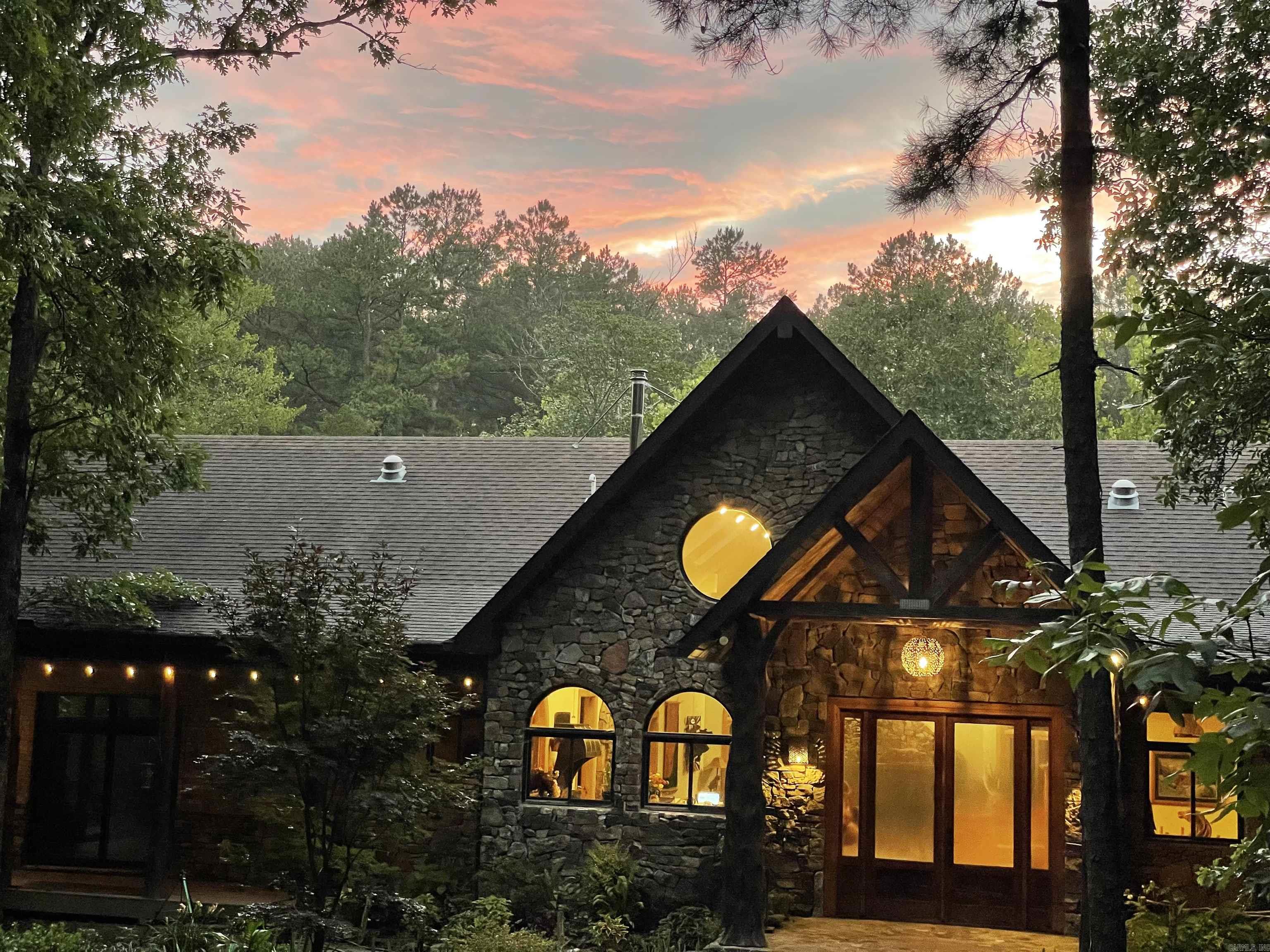 160 ac eco-paradise with luxury home, beautiful mature forest and clear spring fed creek, bordered by National Forest. Perfect for a private nature retreat or mountain bike/equestrian trails. Artistic custom home has cathedral ceilings, open design with many windows and skylights, beautiful native stone and cedar accents, and a 1200 sq ft walk-around deck overlooking the creek and nearby swimming hole. Home has blown-in foam insulation and a geothermal system keeps the house a pleasant temperature, regardless of season. Kitchen is a chef's dream with custom granite-topped hickory cabinets, an island with an extra sink and large panty. Impressive primary suite w/walk in closets and bathroom w/a bidet. 2 spacious bedrooms open onto the deck surrounding the SW sides of the house. Upper-level loft currently used as an office w/Starlink internet. Fully screened outdoor kitchen w/gas range, refrig and farm sink w/dining area and extra seating. Lower walkout level w/creek view has a large screened porch, spacious storage area/FEMA standard storm shelter. Attached 2 car garage, large detached shop/barn with extra bedroom and bathroom as well as a shady deck overlooking a spring-fed pond.