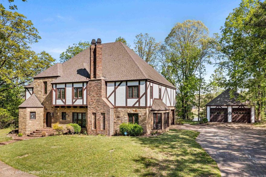 An iconic custom Tudor estate set on one of Cross County’s most coveted ridge-top homesites, this architectural masterpiece blends classic elegance with luxurious comfort. Enjoy sweeping water views, a stately façade with a soaring stone fireplace, and extraordinary craftsmanship throughout. A grand foyer welcomes with a curved staircase and Spanish tile inlaid with hardwood. Rich archways lead to a formal living room with fireplace, a showstopping custom wood-paneled library, a gracious formal dining room, and a marble-accented powder room. The chef’s kitchen features Sub-Zero and KitchenAid appliances, custom cabinetry, a granite island, walk-in pantry, and breakfast nook set in a bay window overlooking the water. Upstairs, the expansive primary suite includes a spa-like bath with soaking tub, walk-in shower, dual vanities, and a cedar-lined walk-in closet. Additional bedrooms include an en-suite guest room and Jack & Jill suite, all with generous walk-in closets. The third floor offers a game room, pool table area, and two flexible bonus spaces perfect for media, fitness, or office use. Rarely does a property of this caliber come available—an exceptional offering on the Ridge.