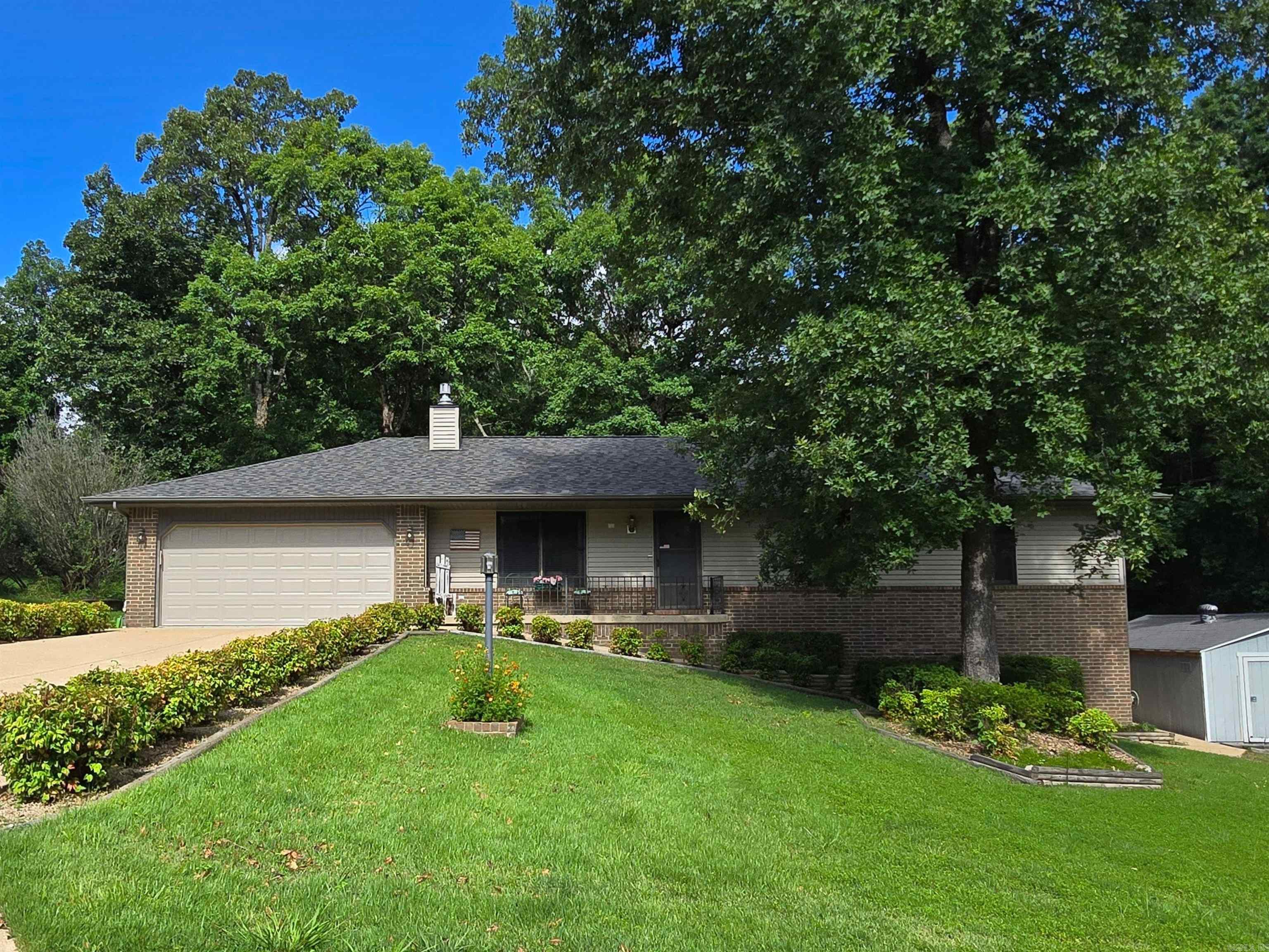 Peaceful setting on 2 large lots (approx. 2.6 acres M/L) located on a quiet court for added privacy. This well-maintained 3-bedroom, 2-bath home features a spacious living room with fireplace, a separate dining room, and a heated/cooled sunroom that overlooks the fenced backyard. The property backs up to woods for serene views and added seclusion. Enjoy mature landscaping, two outbuildings (including a 20x16 shop), and an attached 2-car garage. Home offers 1,799 sq ft of living space, plus a 336 sq ft unfinished basement for storage or potential expansion. Just minutes from Lake Norfork access, perfect for boating, fishing, and outdoor recreation. All this for $269,900!