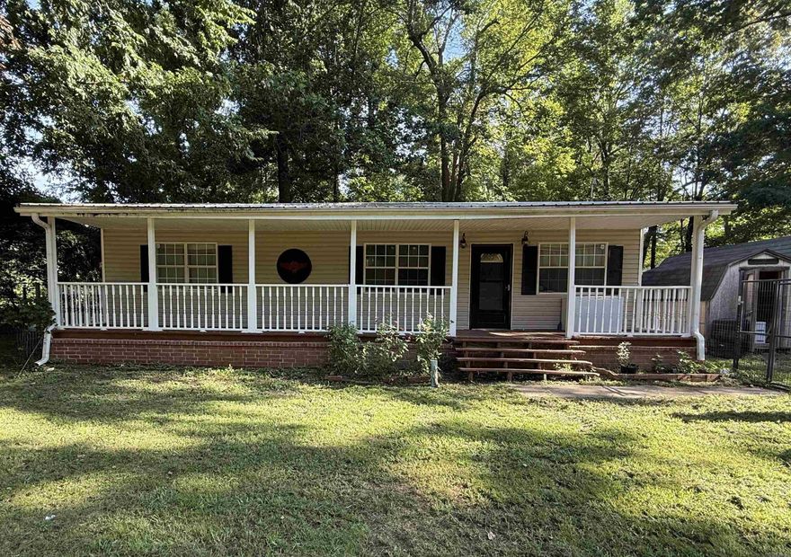 Discover peaceful country living in this charming 3-bedroom, 2-bath home situated on a spacious half-acre lot. With approximately 1,150 square feet of comfortable living space, this property offers the perfect blend of privacy, functionality, and location—just off Highway 351 and conveniently positioned between Paragould and Jonesboro. Enjoy outdoor living from the oversized covered front porch with railings that span the entire front of the home, or relax out back on the covered deck. The property is fenced with durable metal fencing and includes two outbuildings for storage, hobbies, or workspace needs. Recent updates include a new A/C unit and a metal roof for added peace of mind. Whether you're looking for a starter home, downsizing, or just want a quiet retreat with quick access to town, this one is a must-see!