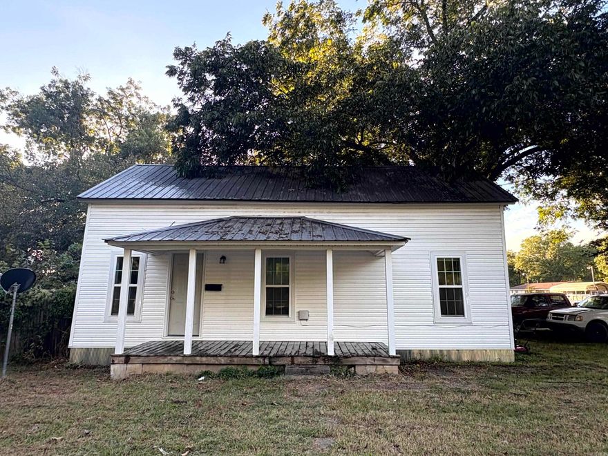 Charming 2 BR cottage in the heart of Paris—just minutes from the town square and The “Paris” Eiffel Tower! Completely remodeled and move-in ready, this home features major updates throughout including a new metal roof (2020), new windows and siding (2024), updated electrical and HVAC system (2023), and fresh sheetrock and flooring (2024). Expansive ceilings create an open and airy feel, complemented by semi-open kitchen and living areas that make entertaining easy. The kitchen is equipped with new cabinetry, solid-surface countertops, an undermount sink, and soft-close drawers, with a gas range, refrigerator, washer, and dryer all conveying. Bright white walls contrast beautifully with warm wood-tone flooring, while the tiled shower adds a modern, stylish touch. A perfect blend of character and contemporary comfort in a prime location!