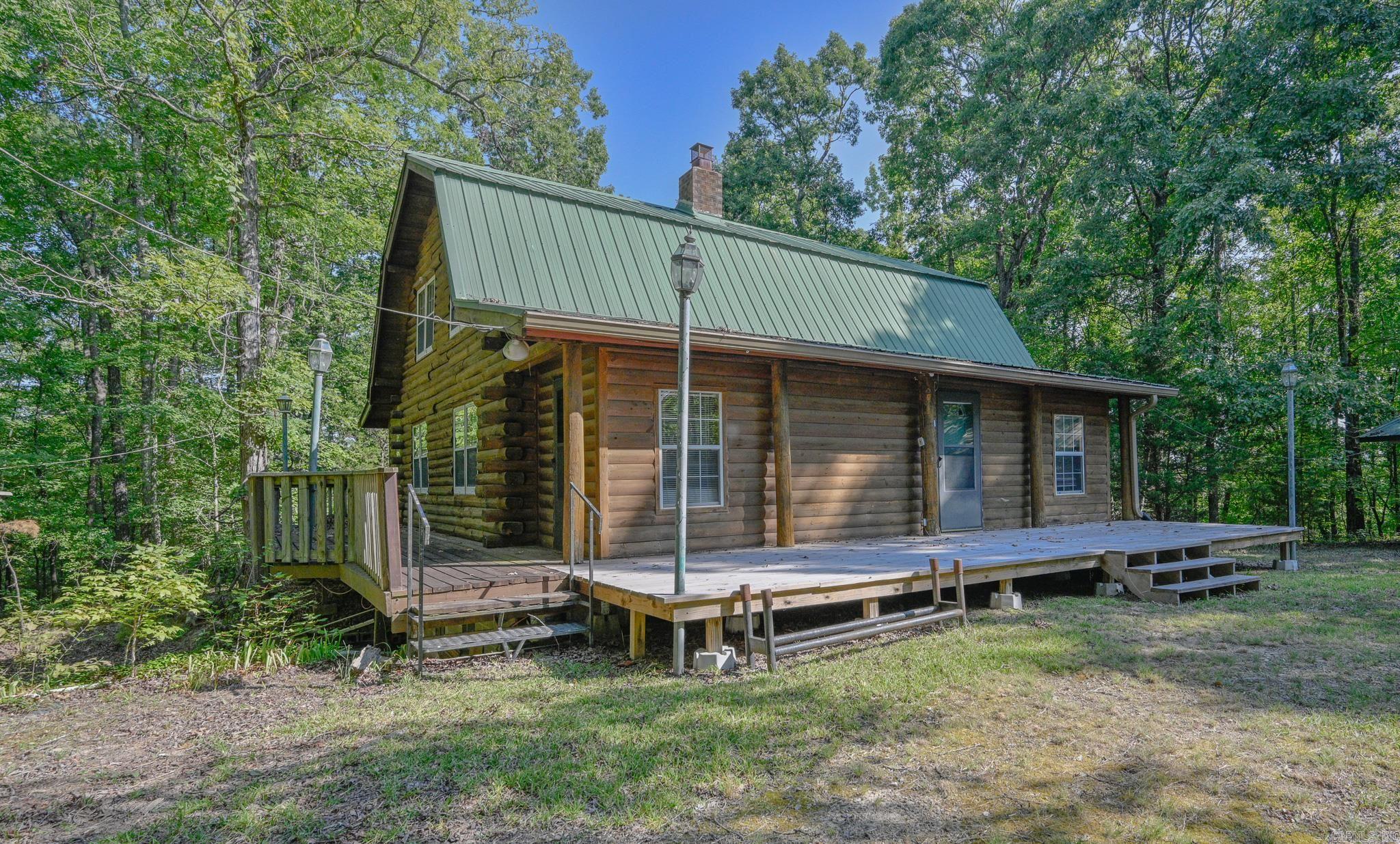 THIS is a REAL LOG HOME.  In the WOODS, QUIET AND PRIVATE.  3.5 acres of Land with lots of mature OAKS, more acreage available if desired.  Joining the NATIONAL FOREST.  The home has 2 levels, one on the ground and one upstairs, containing 2096 square feet according to the courthouse, plus 768 square feet in the basement.  The basement has stairs to the main level, plus an outside entrance.  There are 3-4 bedrooms and 2 bathrooms.  More could be found in the basement if desired.  Great wrap-around deck.  Scenic drive and good fall views of the surrounding mountains.  (Click on Unbranded Video to see mountains.) Access to ATV trails.   5 additional outbuildings, one a 2 car garage, one a shop with wood floor, one a space for an RV with secure shed, and other for storage.  Great area for hunting - deer, turkey, and small game.  In the Hopper, Pike County, area. Joining the National Forest at one boundary. See MLS 24032456 for up to 65 acres!