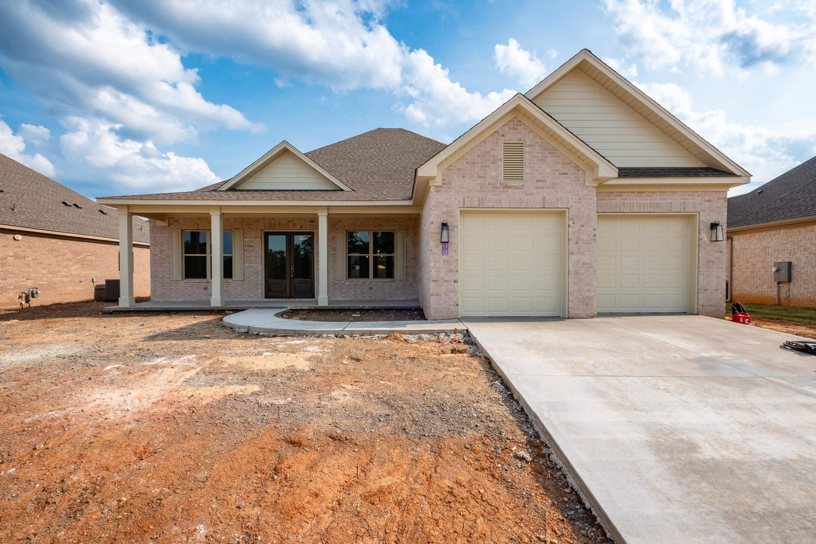 Beautiful ALL BRICK, NEW CONSTRUCTION home is one level on level lot in Country Club of Arkansas Subdivision. Double front doors make for a grand entrance to foyer. Large formal dining room. Spacious living area w/stone to the ceiling fireplace w/electric logs. Living area opens to gourmet chef's kitchen w/Quartz countertops, island/breakfast bar, stainless steel appliances, gas range, convection oven & pantry. Primary suite is fit for royalty. You immediately fall in love with the primary spa bath where you can wash all your cares away; double sink vanities, spa soaking tub and large custom tiled shower. The primary walk-in closet is massive w/built-ins. Separate laundry room leads to primary closet and locker area. Guest room with ensuite and two additional guest rooms with a jack & jill bathroom. Relax on your covered patio after a long day or enjoy entertaining family & friends! Stairs leading to the attic for tons of storage. Make it your home today!