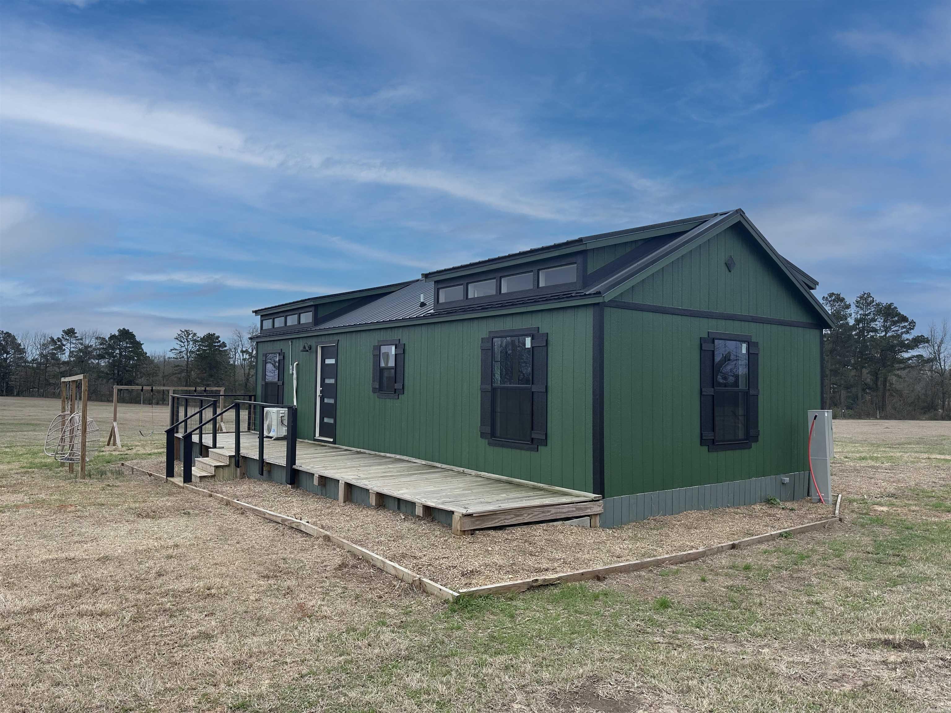 Presenting 12017 County Road 10 on corner of MC 10 & MC 268 - This Mid-Century Modern Cabin Retreat on 5 Acres ā Genoa, AR. Tucked away on five serene acres in the highly regarded Genoa Arkansas Independent School District, this stunning mid-century modern cabin offers the perfect blend of contemporary style and country charm. With two spacious bedrooms and a two massive lofts ideal for the kiddos, this home is designed for both comfort and function. Step inside and be greeted by abundant natural light pouring in through twelve oversized windows, creating a bright and airy living space. The back deck is massive & there are two hanging basket chairs for lounging. With versatile possibilities, this property is perfect as a hunting cabin, horse property, hobby farm, or hobby ranch. Looking for an investment opportunity? And the location? Unbeatable. You will appreciate access to the Genoa Arkansas School District, known for its small class sizes, dedicated teachers, and a strong reputation for academic excellence. A top-tier education, peaceful country living, and endless opportunitiesāthis is the dream property youāve been searching for. Rare gemin the heart of Genoa!