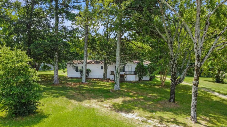 Spacious 4BR/2BA home on 7 level acres directly across from Mills High & Middle Schools! Located outside city limits but with city water, sewer, and trash, this property offers flexibility and convenience. Interior features include engineered hardwood flooring in the living, dining, kitchen, and 4th bedroom, and carpet in the remaining bedrooms. The furnace and AC are just 5 years old. Enjoy outdoor living on the large screened-in porch, plus two storage sheds for extra space. Pre-inspected/FEMA & HUD tags present/Engineer’s letter on file Ideal for a homestead, rental investment, or building your dream home—add additional dwellings for income or family. Plenty of room to grow, just minutes from town!  AGENTS SEE REMARKS