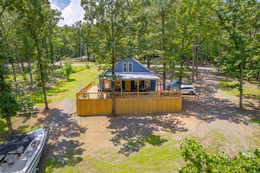 This exceptional lakefront property offers 2.06 acres and features a well-maintained home with two bedrooms, one full bathroom, and one half bathroom. The open living area includes a loft that provides additional space for family or guests, complemented by a wood-burning fireplace. A newly constructed covered deck, completed in May 2025, offers an ideal setting to enjoy the surrounding natural beauty. The property is eligible for a permit to clear a pathway to the water through the white line. Additional amenities include a storage shed and a circular driveway, which allows for easy maneuvering of boats and campers. For further details, please contact me directly.