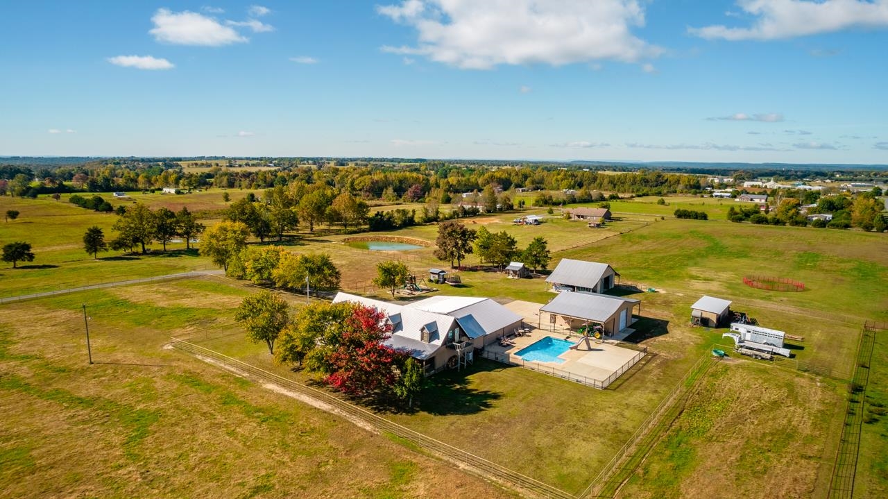 This MUST SEE is 3565 sq ft +/- with 3 bedrooms, but will be 5 bedrooms soon, after windows are installed. There are 3 1/2 bathrooms with half bath outside by the pool and an outdoor shower. 13.5 acres all fenced and cross-fenced with a 30x40 insulated shop with HVAC and a lean-to on each side with an RV Hook-up. Built-in Gun Safe plus, Safe Room, 6-Car Carport and Concrete Floored Horse Barn, Too Much to List!