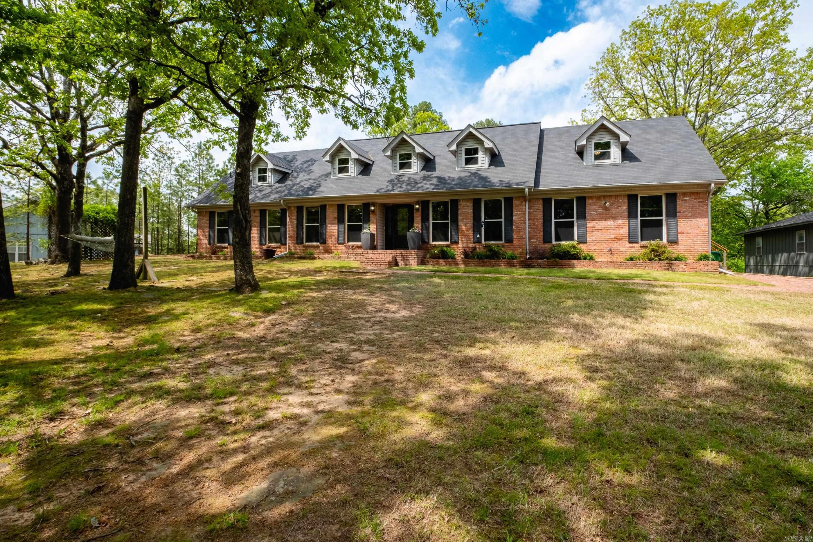Beautiful traditional home secluded from the street, very private location & setting. This lovely property has lots of space including big rooms, fresh paint in many areas & new floors throughout most of the home includes luxury vinyl planking & carpet. Large entry flows into the formal dining room and opposite is a large office or living space. Great Room with stunning brick fireplace & vaulted ceilings plus lots of natural light. Kitchen has so much character with new granite counters, freshly painted cabinets, black appliances - and arched brick area above the cooktop. A full bath for guests on the main level. Primary suite on the main level has a walk-in closet plus spa-like bathroom w/ big tub, walk-in shower and double vanity. Upstairs heads to a big loft area that is a great size for a 2nd living area, gameroom (space for game tables), etc. The upstairs guest bedrooms up are very large - one has its own exterior door to side of home. The large deck from the greatroom overlooks the private backyard. Separate shop/garage is 30x40 (1200 sq ft) and lower level has storage space of approx 570 sq ft. Wilson windows have transferrable lifetime warranty.