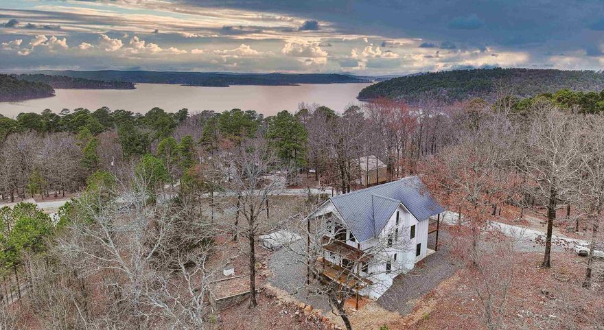 Welcome to your own slice of paradise on beautiful Lake Greeson, just minutes away from Swaha Marina and boat ramp. Nestled on a generous 1.6-acre lot, this brand-new home offers beautiful lake views, perfect for those who love recreational boating, fishing, or simply unwinding in nature’s beauty.  The inviting deck that surround this home make it the perfect place to entertain or sip a cup of coffee and unwind. The two bedrooms upstairs offer their own walk out porch areas for privacy.  Every detail has been carefully crafted with high-end finishes, including stunning alder wood cabinets, solid oak stairs, and a design that maximizes natural light through an abundance of windows. Looking for storage or a  place to park your boat? There’s room to spare with flood lights included! Perfect for weekend getaways, family retreats, or full-time lake living, this home combines comfort, style, and the very best of lake living. Extras include: sprayfoam insulation on exterior walls, ceiling and upstairs flooring. 2 HVAC units, tankless water heater, blocks on raised slab have been sealed as a water barrier for moisture protection inside slab.