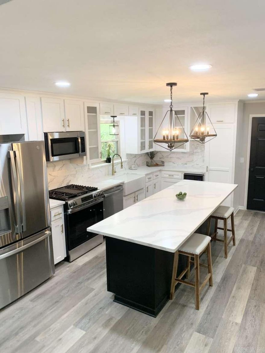 This beautifully designed farmhouse offers a tasteful blend of elegance and modern comfort. The spacious open floor plan features four large bedrooms, all with ample closet space and LVP flooring. Upon arriving, you’ll love the front porch where you can sit out and enjoy your morning coffee. Step inside and discover a sleek accent wall featuring an electric fireplace, ensuring a relaxing atmosphere and cozy nights. Seamlessly, transition to the kitchen where you will find a large island with quartz countertops, lots of cabinets with gold accents, a beverage cooler, wine cabinet, farmhouse sink and stainless steel appliances. Enter into the master bedroom where the stylish barn door invites you to the en-suite bathroom with a large custom marble tiled shower, his and her sinks and beautiful wooden accents. Many updates includes new roof, hvac unit, windows and hot water heater (2025). Outside, the deck provides a relaxing oasis to unwind and enjoy a view of the private fenced backyard. Park your RV, boat or truck on this manicured lot that spans over 1.2 acre. This is more than just a house, it’s the lifestyle you’ve been waiting for!