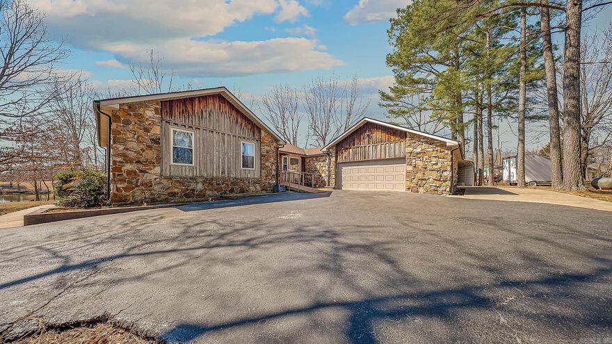 Tucked into the trees on a quiet dead-end street, this rustic retreat sits on two lots totaling approximately 0.80 acres and offers the perfect blend of privacy and neighborhood charm. Cypress siding and natural stone accents complement the wooded setting and shared lake access, creating a peaceful backdrop for everyday living. Enjoy morning coffee or evening sunsets from the spacious screened porch overlooking the lake. The main level features three bedrooms, two baths and hardwood flooring, while the walk-out basement offers two additional bedrooms, living spaces and a full bath, ideal for guests, hobbies, or flexible entertaining space. The updated kitchen includes granite countertops and newer appliances, opening to comfortable gathering areas designed for both entertaining and relaxing. With 1622 sf on the main level and a finished 1428 sf basement and double garage, this home provides both character and functionality. A rare opportunity to enjoy space, nature, and lake-area living — all in one inviting package.