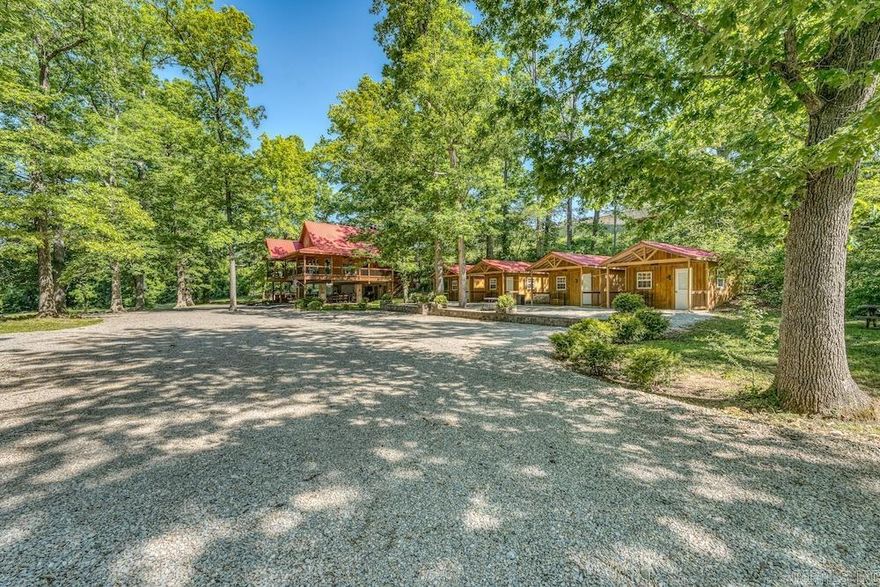 This rare Spring River property near Mammoth Spring offers nearly 700 feet of river frontage, ownership of roughly three-quarters of a private island, and direct access to world-class trout fishing and floating. Tucked beneath towering white oaks with gated entry and paved access, the property feels secluded while remaining just minutes from town, Mammoth Spring State Park, and the fish hatchery. The fully furnished 1,500 sq. ft. lodge features vaulted ceilings, custom woodwork, granite countertops, stainless appliances, spacious living areas, and a large covered deck overlooking the river. A covered outdoor entertainment pavilion includes grills, TVs, custom seating, and full bath facilities, perfect for hosting guests or corporate retreats. Additional improvements include a blacktopped drive, custom firepit area, and four furnished guest cabins with private porches and mini-splits. Turn-key and income-producing ready, this one-of-a-kind Ozark retreat offers privacy, recreation, and investment potential in an unmatched riverfront setting.