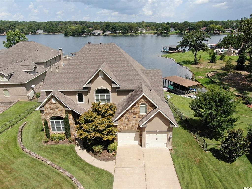 LUXURIOUS WATERFRONT ESTATE IN MUCH SOUGHT AFTER WATER OAKS ESTATES. 4 BEDROOM 3.5 BATH WITH TWOBONUS ROOMS PLUS AN OFFICE WITH A LAKE VIEW. MASTER SUITE WITH FIREPLACE ON MAIN LEVEL, EAT IN KITCHENWITH GRANITE COUNTERS AND STAINLESS APPLIANCES. LIVING ROOM WITH STONE FIREPLACE AND SOARING CEILINGS!FORMAL DINING ROOM, LARGE LAUNDRY ROOM AND COVERED BOAT DOCK w/ LIFT. EXPANSIVE LAKE VISTAS AREYOURS TO ENJOY EVERY MINUTE OF EVERY DAY! THIS PLACE IS A LAKEFRONT PARADISE! BOAT AND RV STORAGE