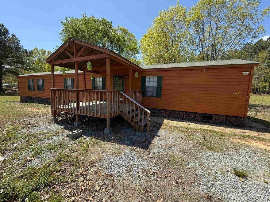 Immaculate, HUD-certified 3 bed, 2 bath manufactured home on 1 surveyed acre in Bauxite. Enjoy peaceful country living just minutes from town. This 1,280 sq ft home features a security system with glass break detection, fire monitoring, front/back cameras, and keypad entry. The split floor plan offers a master suite with walk-in closet, shower, and soaker tub on one side, and two bedrooms with a full bath on the other. Open-concept living/kitchen includes refrigerator, stove, dishwasher, microwave, garbage disposal, and a digital LE washer/dryer set. Covered front and back porches, with the back porch fenced-in, plus a play area, 6-ft dog run, and shaded backyard with in-ground storm shelter. A 30x40 shop with front/back roll-up doors and attached 10x40 lean-to offers ample storage. Home warranty paid through Sept 2025.