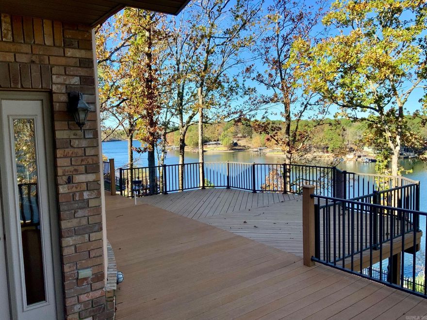 Discover your dream escape in this beautiful 4 bedroom, 3.5 bath lake house. Immerse yourself in breathtaking lake views from the deck that over looks the water and perfect for sunset views. A wrap around porch completes the look of this spacious brick home. Beautiful custom cabinets in the kitchen. Enjoy the ultimate convenience with two primary suites on the main level. A dedicated office space offers a quiet retreat for work or hobbies. The oversized two-car garage provides ample space for your vehicles and toys. Cozy up by the gas log fireplace surrounded by built ins on cooler evenings. Boat dock and trolley included for endless water adventures. Don't miss this opportunity to experience lakefront living at its finest! Take advantage of the beautiful neighborhood, offering easy access to shopping and dining.