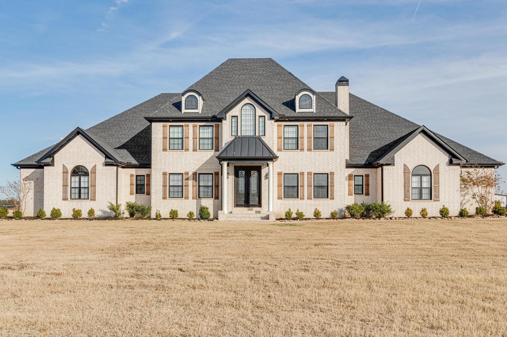 This exceptional home offers an enchanting blend of old world country charm and modern amenities. With 12.60 unrestricted acres, this property provides abundant space and privacy. Built in 2018, the residence boasts a charming 30x30 barn and pond, perfect for gardening enthusiasts or those seeking a tranquil retreat. The heart of the home is its remarkable double island granite kitchen open great room & huge brick columned dining area. The kitchen is complemented by a hidden pantry, allowing for seamless organization and storage. The open floor plan creates a seamless flow between the kitchen, dining area, and bonus area, making it ideal for entertaining. The house features 4 to 5 spacious bedrooms, offering ample room for accommodating guests or even a bed & breakfast, or event center option. Four en-suites and two half bathrooms provide convenience and ensure that everyone's needs are met. Additionally, the home includes a playroom, an office, and a home gym, catering to various lifestyle preferences. A three-car garage offers plenty of space for vehicles and staircase to attic storage or finish for more space, tankless water heaters, safe room in primary closet, and much more!