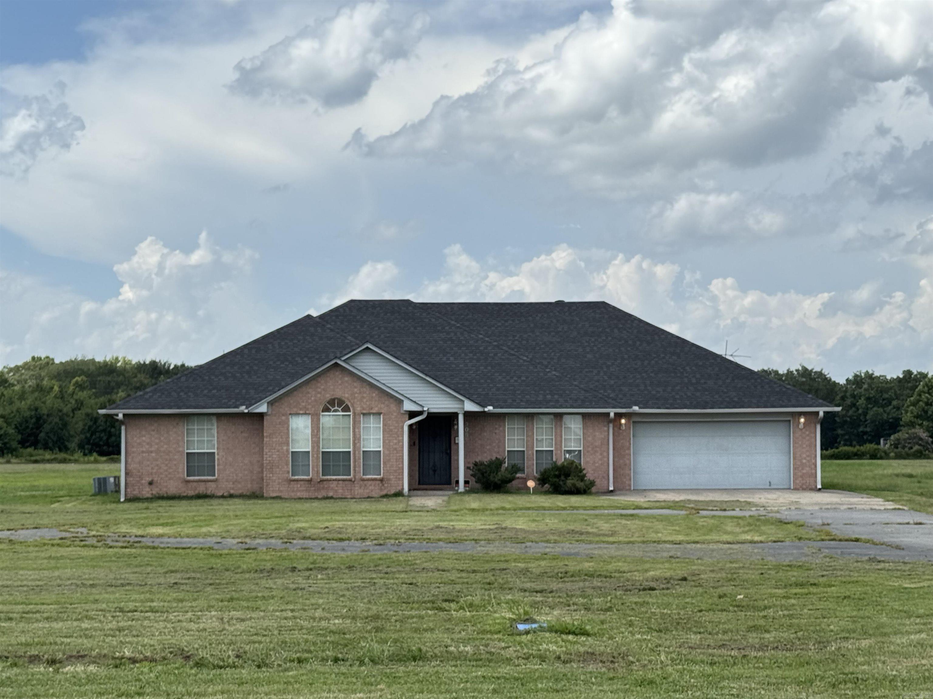 Looking for a home out of town? This Brick one story custom build home has all a family needs! The kitchen is spacious and has a seating area for a small table on one end, and a separate formal dining room on the other end. The living area is large and open with a gas log fireplace and wood floors. There are three bedrooms, one hall bathroom, and an en-suite in the master bedroom area. The master bathroom has had a recent shower upgrade with beautiful white and grey tiles. The house has a two car garage attached, and a large shop out back 23' x 35' with a pull up garage door. If you are looking for more space, the yard is 6 acres. This house is in the country with quick drive to Humphrey, Stuttgart, and the Bayou Meto hunting grounds.