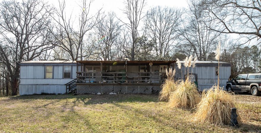 Opportunity meets acreage on this 8-acre property located just outside city limits. With multiple potential build sites, existing utilities, and income-producing possibilities, this property offers strong upside potential.   The current mobile home allows for immediate occupancy or rental income while additional development plans are made.  Two powered workshops add functional value for equipment storage, business use, or tenant amenities. Horse stables and open acreage expand the appeal to rural renters or future buyers seeking small-farm flexibility.  A secondary structure on-site is uninhabitable and ready for tear-down - presenting an opportunity to improve the property footprint and increase overall value. Whether you're looking to: • Develop a custom build site • Add rental income • Hold as a land investment  This property offers flexibility, infrastructure, and long-term growth potential.