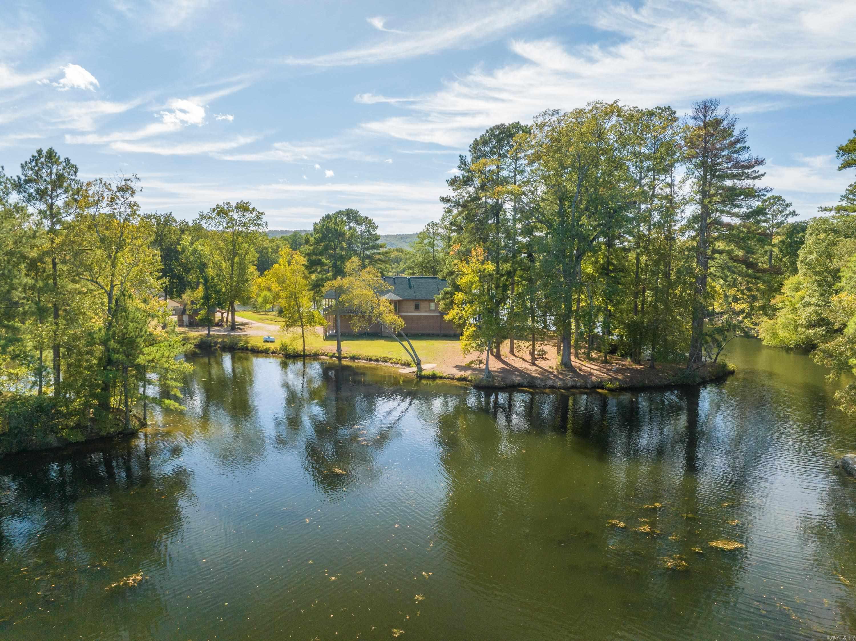 Welcome to your private oasis on a 2.8-acre peninsula, boasting an impressive 1700 feet of pristine lake frontage! This exquisite property offers the perfect blend of rustic charm and modern luxury. Nestled amidst nature's beauty, the primary residence is a custom-built 3-bedroom, 2-bathroom masterpiece. Crafted with a keen eye for detail, it exudes rustic character. The spacious living area features a stone fireplace and panoramic windows that frame stunning lake views. The chef's kitchen is well-appointed with top-of-the-line appliances and a large island. Two 1-bedroom, 1-bathroom cabins offer guests a cozy retreat. Perfectly situated for privacy, they provide an ideal spot for extended family or rental income potential. Outside, enjoy endless activities from your own backyard. Fish, swim, or kayak from your private dock. Explore the surrounding woods, or simply unwind on the sprawling deck overlooking the serene waters. The enchanting sunsets will leave you in awe. This unique property combines the serenity of lake living or the potential for instant cash-flow through an already successful and profitable VRBO business! VRBO Financials available on request.
