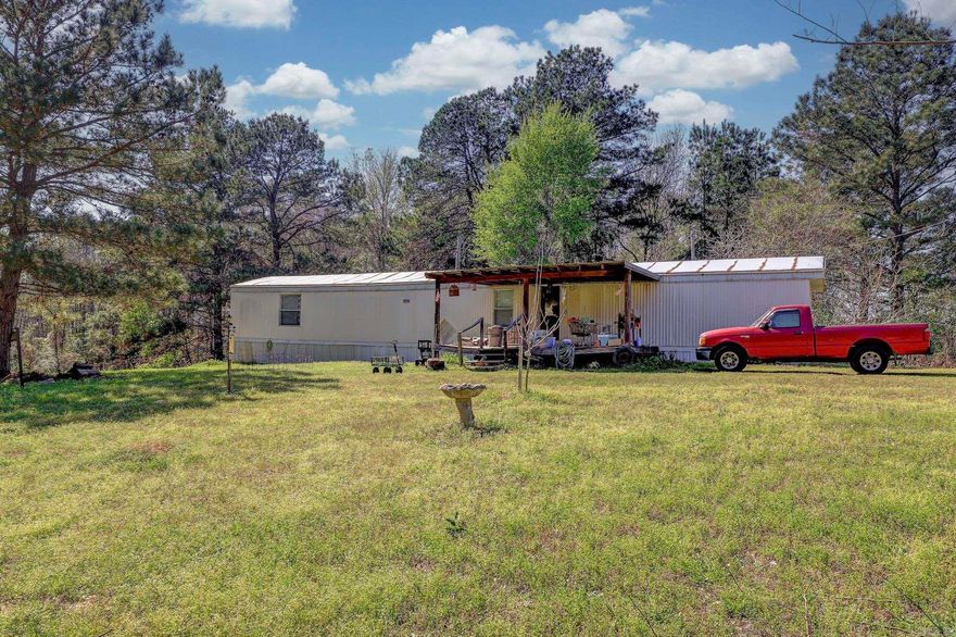Nestled on 1.7 acres in the desirable Fouke School District, this 3-bedroom, 2-bath manufactured home, built in 2002, offers a large covered front deck perfect for relaxing. The spacious lot features a fantastic garden site, and the home is equipped with electricity, public water, and a septic system. While the home needs some TLC, this peaceful setting and endless potential make it a great opportunity for renovation or a custom build.