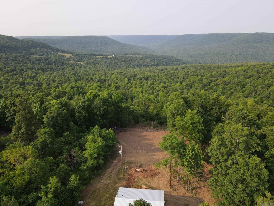 What an opportunity and what a location! This stunning tract is loaded with features you just can’t duplicate, with some absolutely mesmerizing views. Located near the coveted Calf Creek, Buffalo National River, Richland Valley, and more, this parklike acreage draws you in as it encompasses the true nature of the Ozark mountains. The cute and quaint cabin boasts new waterproof laminate flooring, new drywall, rustic touches, custom accents, one full bath, two bedrooms, new cabinetry, a living/kitchen combo, and a breathtaking vista view of the scenic mountains off of the beautiful back deck. The cabin also features custom wood trim, a new on-demand hot water heater, a propane tank, new stainless appliances, a washer/dryer, custom doors, and more. Nestled in the heart of the tract, the cabin is strategically set to maintain the utmost privacy and seclusion for guests to truly escape the worries of life. The property boasts quality access off the well-maintained county road, electricity, a well and well house, and a new septic system. The rolling topography and gorgeous timber combine to create the ideal investment potential.