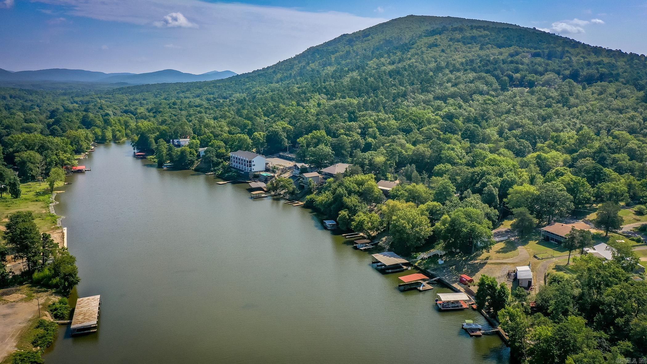 This listing presents a fully-furnished, well-remodeled short-term rental lake home located at 115 Ledgerock Road, Hot Springs, Arkansas, and it promises a living experience like no other. With exclusive Lake Hamilton access and a covered dock, indulging in waterfront recreation is no longer a distant dream but an everyday reality.  As you step into the residence, you’re immediately met with the undeniable warmth and comfort of this welcoming abode characterized by tasteful decor and high-quality fixtures. Experience the perfect fusion of practical layout and quality workmanship throughout the property, emblematic of a considerate thought process in design.  The heart of this home is undoubtedly its spacious, covered deck. Meticulously maintained, it presents a panoramic view of Lake Hamilton’s serene waters. This vantage point sets the stage for lazy Sundays, mesmerizing sunsets and memorable entertaining scenes, resonating with the harmonious rhythm of the lake’s waters.  Integral to this home is its Lake Hamilton access. With the inclusion of a covered dock, this waterfront property opens avenues for adventurous or leisurely aquatic activities, encapsulating the tranquility...