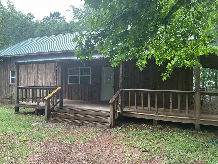 LAKEFRONT CABIN WITH 2 STALL PRIVATE DOCK & approx. 242 feet of lakefrontage. What a fantastic setting with a gentle walk to the dock (northern end of property) & amazing rock formations (southern end). Privacy and total happiness are another two things you will have along with this rustic home featuring 3 covered porches & a sun deck.  Inside you will find an open floorplan, 2 bedrooms (separated), 2 baths (both with walk-in showers), large kitchen (with breakfast bar) & a washer/dryer pantry. You can walk to the Circle Acres launching ramp.
