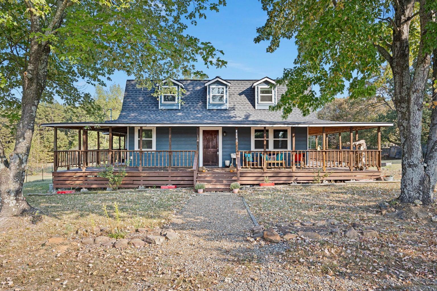 Step into your perfect country haven with this delightful two-story, barn-style home set on 2.18 acres. Featuring 4 spacious bedrooms and 2 beautifully appointed bathrooms, this 1,624 sq. ft. home offers the perfect blend of comfort and style. The main level features a cozy living room, followed by a completely updated kitchen, and a primary bedroom conveniently located next to a bathroom with a deep soaker tub. Upstairs, you'll find three additional bedrooms and a full bath, perfect for family or guests. Outside, dive into relaxation under the expansive wrap around porch, or next to your pool, and utilize the detached garage and heated and cooled workshop for all your hobbies. Experience country living at its finest!