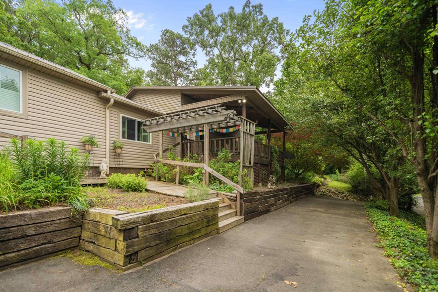 A unique home in a peaceful setting. Circle drive with abundant joining flower beds. Covered front porch with ceiling fans and adjoining deck. Open kitchen, living and dining. Spacious kitchen with abundant natural light, island & large cabinet style pantry. Master bedroom has tray ceiling & walkin closet. Master bath has jacuzzi tub & walkin shower. One guest bedroom has tray ceiling, built-ins & tile shower. Third bedroom has vaulted ceiling. Utility room is also a full bath. Garden room with utility sink. Plantation shutters in two rooms. Privacy fence north of home, wooded seclusion east & south, wildlife abounds. Well house, outside storage & carport in backyard. Includes three parcels, home, vacant lot to side and lot across street. A labor of love during current owners four year ownership. Improvements include new windows, new interior paint, stainless Moen sink, two hot water heaters 2022, Bosch dishwasher 2025, Microwave & cook stove 2022, new well pump, HVAC serviced, master bath tile floor, leaf filters on gutters, mini split & carport. Refrigerator conveys. Survey on file. Curtains and area rugs do not convey.