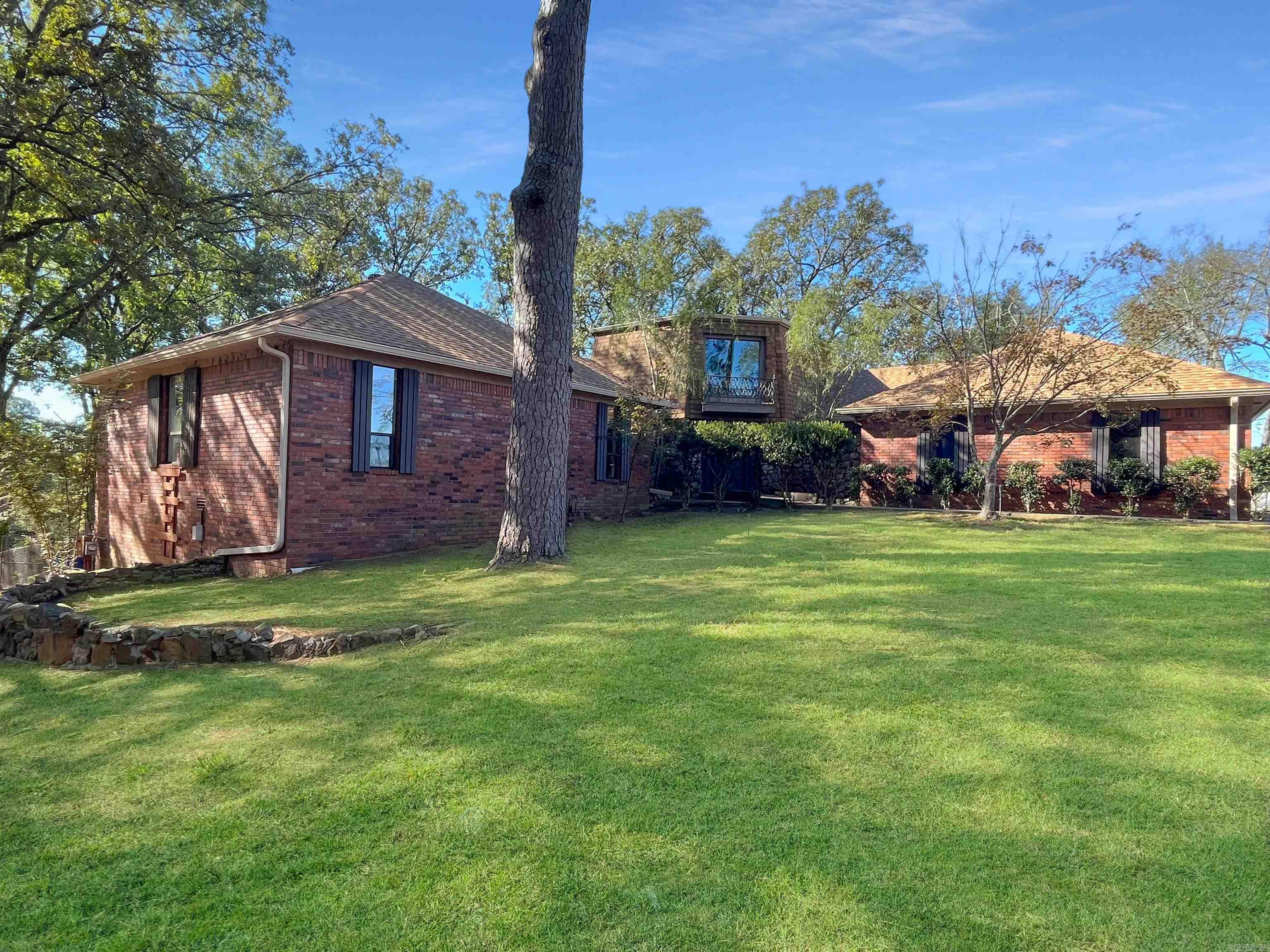 This lake home sits on 1.63 acres on Lake Hamilton. There's so much potential this home has! It features 4 bedrooms 3.5 bathrooms, an open floor concept which has a wood burning fireplace and a deck that overlooks the spacious backyard. Basment downstairs is finished and also has a fireplace and plenty of storage and leads to a porch downstairs. It's heated a cooled by a window unit. An outside kitchen is located near the lake. There's a covered boatslip being repaired! BRAND NEW ROOFS will be on Home,outside kitchenette, and the covered boat dock!!!! Make this home your own or turn it into your next investment! Please note that this home will be sold as is.
