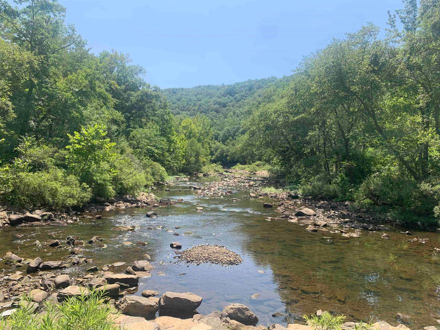 Just reduced! Beautiful Middle Little Red River frontage! This gorgeous property has so much interesting history being the heart of the historic railroad ghost town of Arlberg, has approx 600 feet of river frontage, is mostly level to slightly sloping, and corners the low water bridge and Angora Mountain Road providing easy access just off HWY 110. The property sits directly across from stone pillars remaining of the canning kitchen that supplied food for the city’s orphanage a hundred years ago. The sound of the river flowing by, and views of the beautiful surrounding mountains from this peaceful property is literally mesmerizing. Power is available and in very close proximity to the property with structures nearby but not visible providing complete privacy. This is an ideal property for a vacation cabin or for building a dream home. This area is a hunter's paradise too with an abundance of Whitetail deer and small game. No restrictions. Well and private septic necessary for structures. Live the dream in the beautiful Ozarks with your own fishing and swimming hole in a clean mountain stream! Full of rich history and beauty with a concrete platform of old Alberg train station!