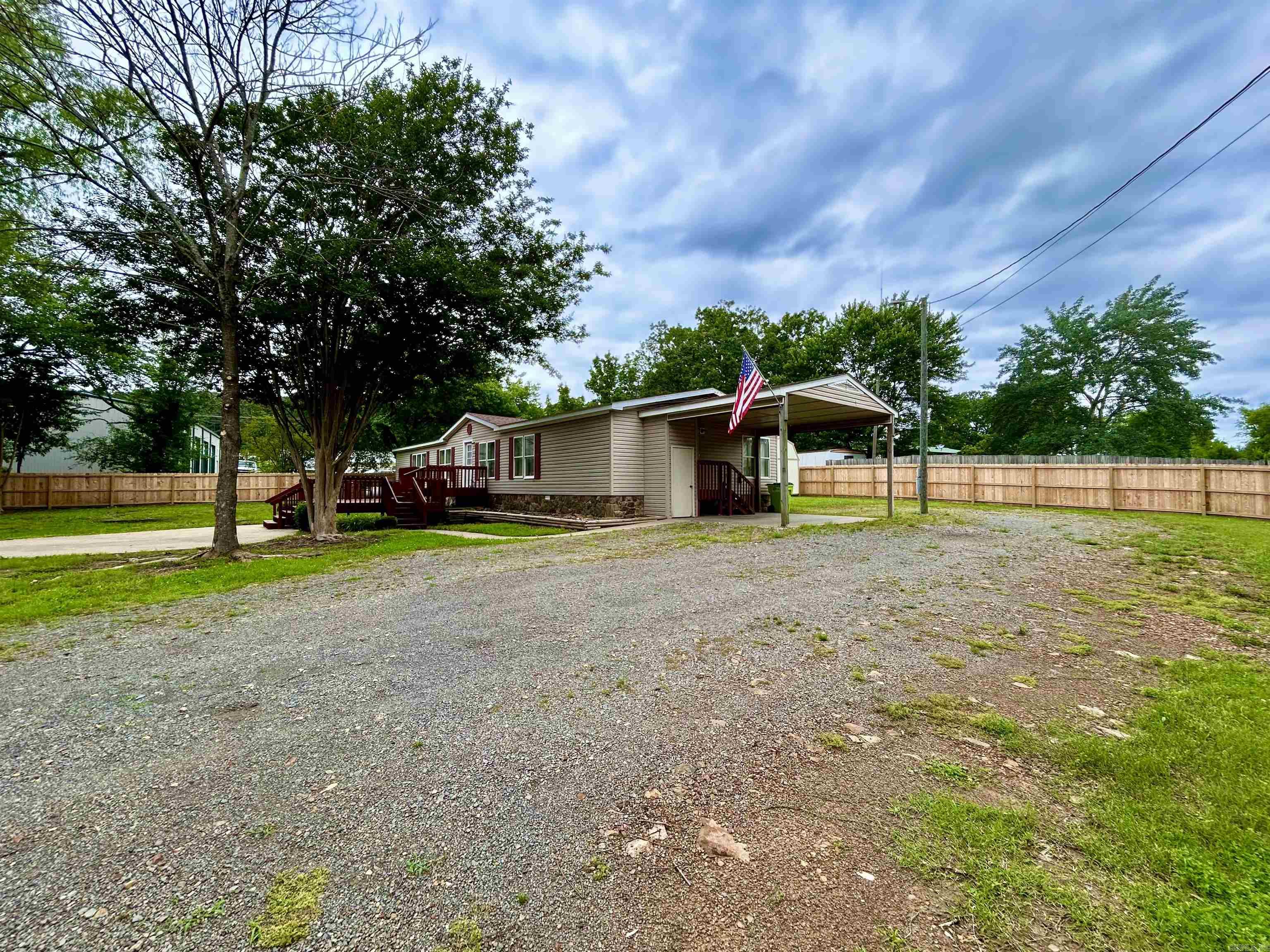 Located in the quiet town of Clinton, Arkansas, 579 H Street is a well-maintained 3-bedroom, 3-bath manufactured home offering 1,820 square feet of comfortable living space. Built in 1999 on a 0.73-acre lot, this home features a spacious master suite with dual Jack and Jill bathrooms, a versatile bonus room, formal dining area, a breakfast nook, and a functional kitchen with a new refrigerator and essential appliances. Recent updates include a new roof, new HVAC unit, new storage building, and added privacy features. Additional highlights include a dedicated laundry room, electric heating and cooling with a heat pump, and a mix of carpet and vinyl flooring. Outside, enjoy a large front deck, patio, and carport. All just minutes from downtown Clinton and Choctaw Marina.