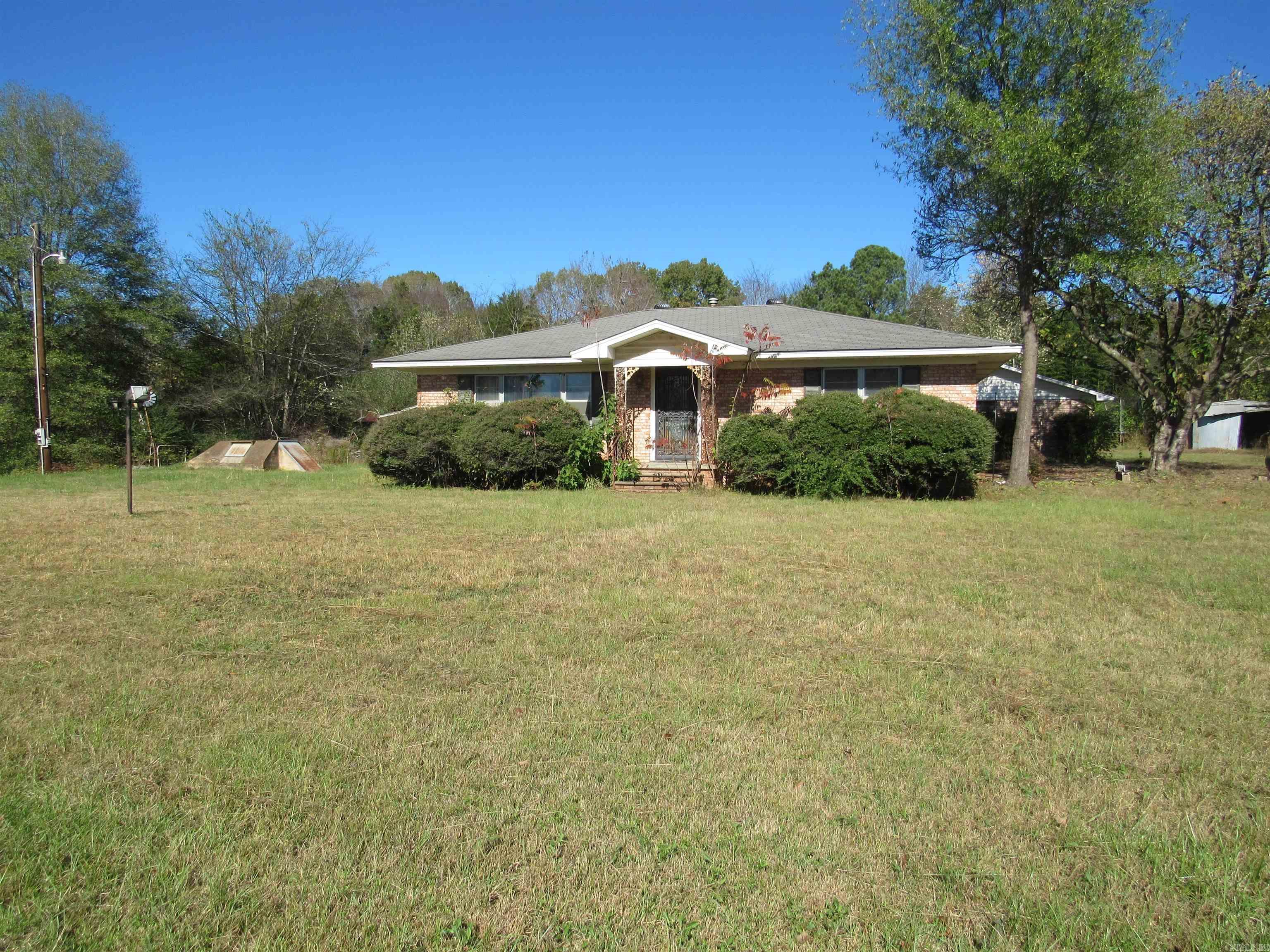 AIN'T GONNA LIE. THIS ONE NEEDS SOME LOVE. SELLER SAYS THT THE HOUSE WAS BUILT BY A FAMILY MEMBER THAT WAS IN THE CONSTRUCTION BUSINESS AND BEST PRACTICES WERE USED TO BUILD THIS HOME FOR HIS FAMILY. IT HAS BEEN VACANT FOR A FEW YEARS AND NEEDS A NEW BUYER TO BRING IT BACK UP TO FORMER STANDARDS. THERE ARE SEVERAL OUTBUILDINGS INCLUDING A ALL BRICK TWO CAR GARAGE/WORKSHOP WITH AN ADJOINING CANNING ROOM. THE CANNING ROOM INCLUDES A SMALL KITCHEN, A TOILET AND SHOWER, REFRIGERATOR AND A PLACE FOR A STOVE. THERE IS A SMALL ROOM OFF THE PATIO THT HAS BEEN USED AS A BEDROOM. A TRACTOR, PORTABLE STORAGE BUILDING AND A TRUCK ARE NOT INCLUDED IN THE SALE AND WILL BE MOVED PRIOR TO CLOSING. ALL OF SELLER'S PERSONAL PROPERTY LEFT AT CLOSING BECOMES THE PROPERTY OF THE BUYER. SELLER WILL NOT TURN ON UTILITIES BUT WILL GIVE PERMISSION FOR THE BUYER IF NEEDED. THE PROPERTY IS BEING SOLD AS-IS IN ITS PRESENT CONDITION. YOU MUST HAVE A REALTOR PRESENT TO ENTER PROPERTY.