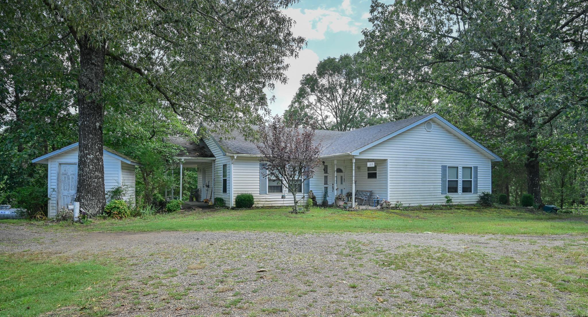 This charming, gated, almost 6-acre farmette features two houses and a mobile home. House 1: 2 bed/2 bath, open concept floorplan with lots of natural light. House 2: 2bed/2 bath, cozy bungalow with wood burning fireplace and sunroom. Dwelling 3: single wide mobile home with screened porch. For the livestock, you will find a barn, stables with eight stalls, a tack house, a chicken coop, and rabbit hutches. The pasture is fully fenced and cross-fenced. Additionally, you'll find a 24x60 workshop and a 16x36 workshop. A spring-fed creek feeds the one-acre stocked pond. Luscious landscaping boasts fruit trees that include apple, pear, and fig, along with mature trees and several ornamental plants that attract the local deer. One side of the property borders Polk Rd 92.