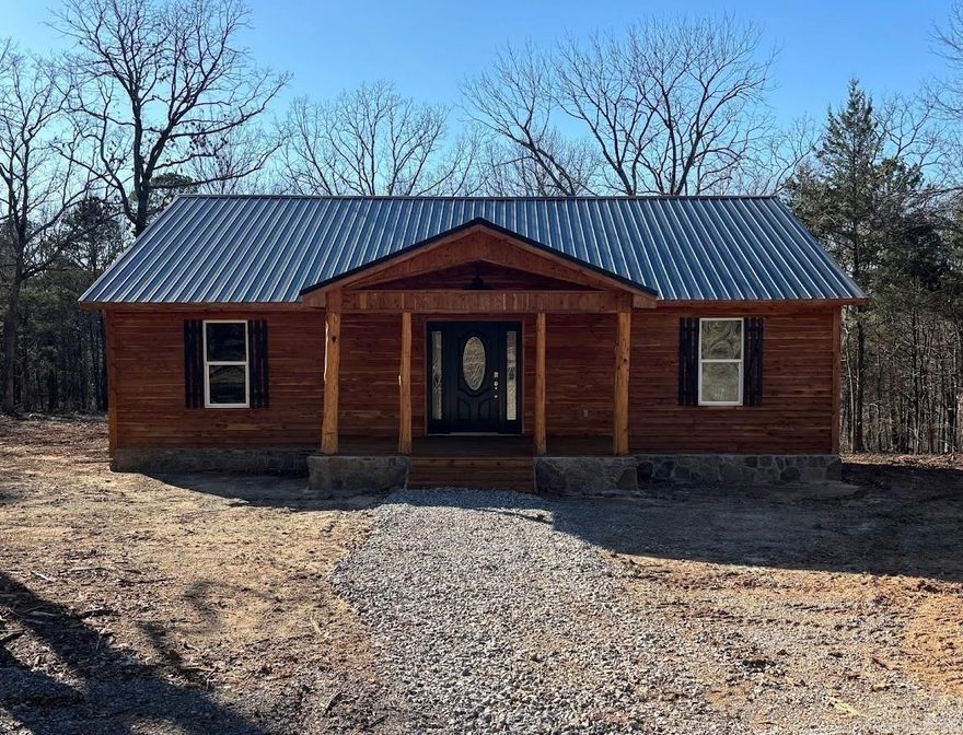 Welcome to this beautiful, newly constructed home featuring a cedar wood exterior that showcases rustic appeal and natural durability. The property boasts a metal roof, stone foundation accents and a covered front porch supported by natural log posts. Step inside to the continued cozy feel of rustic accents including cedar covered ceiling and polished wood floors.  A vaulted ceiling and recessed lighting create an inviting, spacious atmosphere. Kitchen is equipped with wood cabinetry and granite countertops, along with stainless steel appliances. Step outside to the covered back deck for your own private retreat overlooking 2,000+ acres of timber company land, also known as Cherokee Wildlife Management Area. Enjoy all the wildlife nature has to offer right from the comfort of your home!