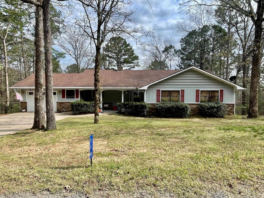 Well maintained home on a quiet, dead-end street in the Mountain Ranch area of Fairfield Bay. Enjoy the large screened-in back porch with a view of the mountains, accessible from the dining room, living room, and primary bedroom. Interior has been painted, new carpet in bedrooms, exterior shutters painted. Refrigerator, washer, and dryer stay. Some furnishings will remain. Large primary suite has double closets and ensuite bath. Woodburning fireplace. Oversized, single garage. Under home, you will find an expansive space for storage, along with an area set up as a workshop space (see photo). No neighbors on either side gives you a feeling of seclusion, but yet you're close to all the amenities Fairfield Bay has to offer, such as bowling, hiking, ATV and UTV trails, fitness center, restaurants, grocery store, park, golf courses, marina...the list goes on. Set up your showing today!