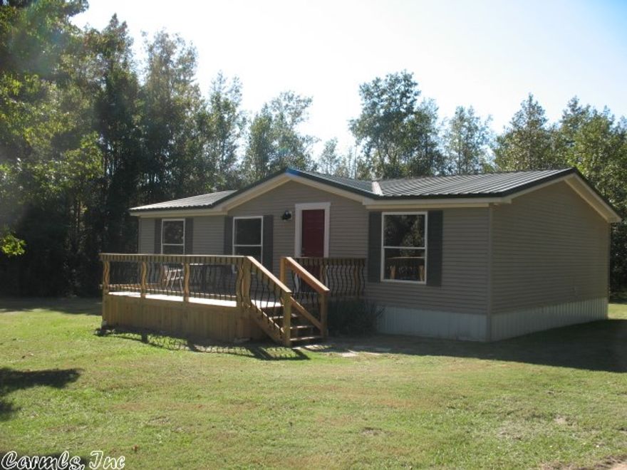 This nice mobile home has a lot of brand new features. New paint, flooring, tile showers, gravel drive, metal roof, and a deck in the front/back. Also a gravel drive way, and the storage building stays. Great value, won't last long. Set up FHA with engineers approval letter.