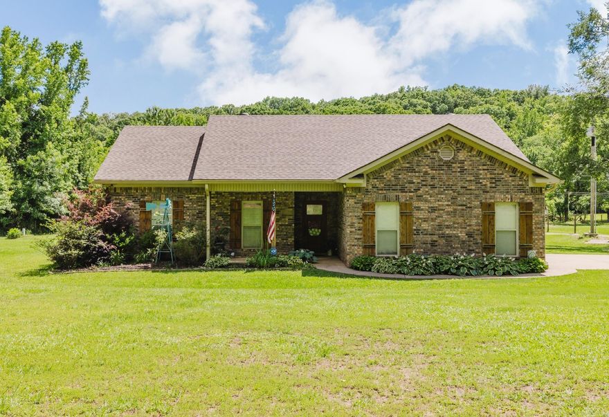 Nestled on 6 picturesque acres of rolling land, this charming country home offers 1,612 square feet of comfortable, inviting living space. It is a rare find that perfectly balances rural tranquility with practical, modern updates. Step inside to an expansive, open-concept layout designed for both easy daily living and effortless entertaining. The heart of the home features a spacious living room that flows seamlessly into a bright kitchen and dining area, offering plenty of room for family gatherings. The primary suite serves as a peaceful retreat, complete with its own private bathroom, while two additional well-sized bedrooms share a clean, full secondary bath—perfect for children, guests, or a dedicated home office.  Peace of mind comes standard with this property, as the home had a brand-new roof in 2022, ensuring excellent structural protection and energy efficiency for years to come.  Step out into your own private outdoor paradise. A sparkling above-ground swimming pool, creating the ultimate setup for summer barbecues, sunbathing, and cooling off on warm afternoons. Whether you are looking to tinker in the 24X60 shop, float in the pool, or explore your own private creek bed