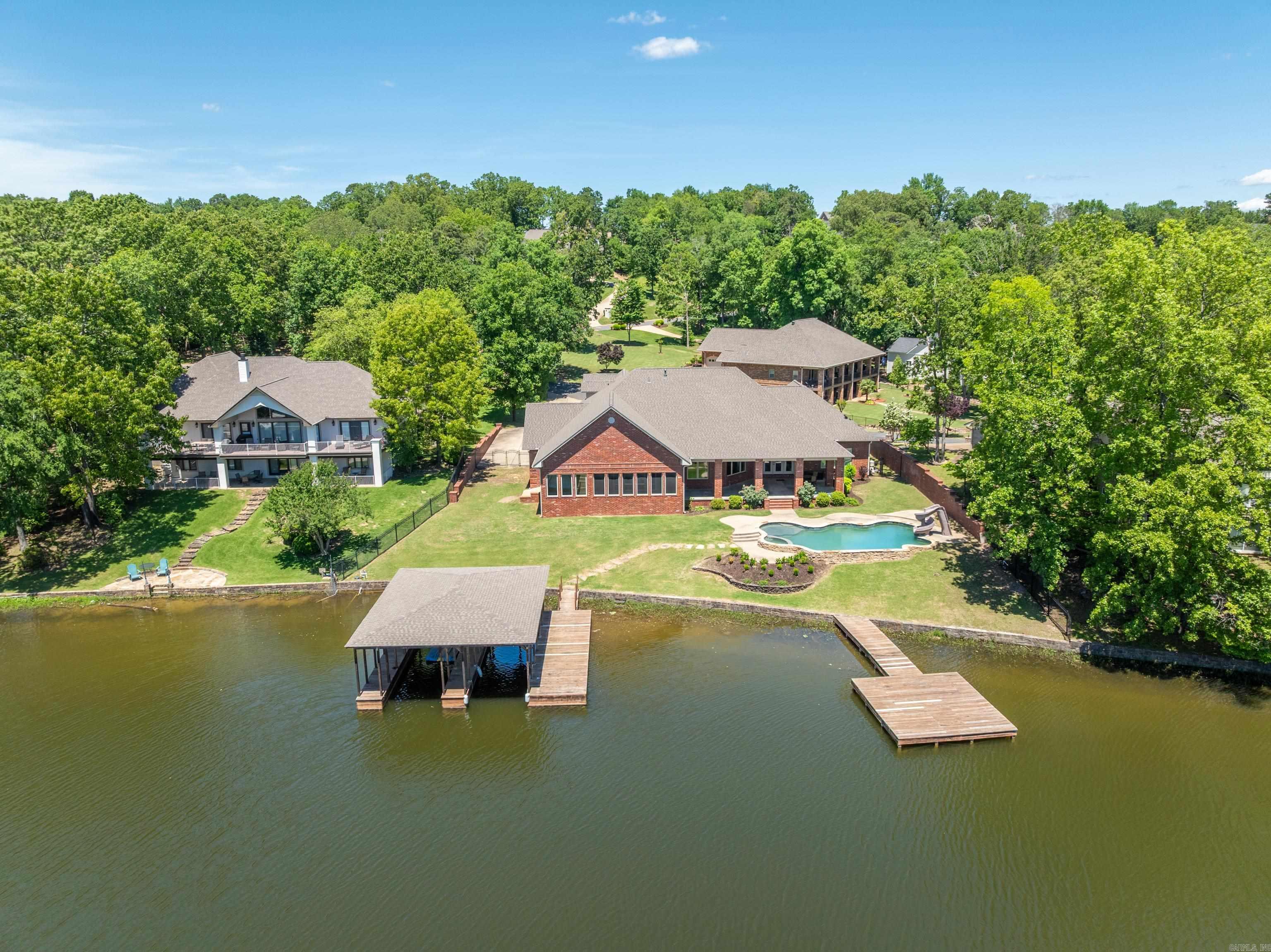 Custom Lake House on Lake Hamilton - A Waterfront Dream Home Discover an extraordinary custom-built lake house, perfectlypositioned on the serene shores of Lake Hamilton. This remarkable property spans 0.66 acres with an impressive 154 feet of lakefrontage, offering unparalleled views and direct access to the water. Spacious Living: With over 4,600 sq ft of living space, this homefeatures 5 bedrooms and 4 bathrooms, providing ample room for family and guests. Gourmet Kitchen: The large gourmet kitchen is achefās dream, boasting top-of-the-line appliances, custom cabinetry, and expansive countertopsāideal for preparing meals andentertaining. Multiple Living Areas: Designed for comfort and versatility, the home includes multiple living areas, perfect for relaxing orhosting gatherings. Two cozy fireplaces add warmth and charm to the main living spaces. Primary Ensuite: The large primary ensuite isa true retreat, offering a luxurious bathroom and generous closet space. Outdoor Entertaining: The outdoor areas are an entertainer'sparadise, featuring a spacious screened-in porch, ample decking, and various spots to enjoy the lake views. Dive into the in-groundGunnite pool, complete with a