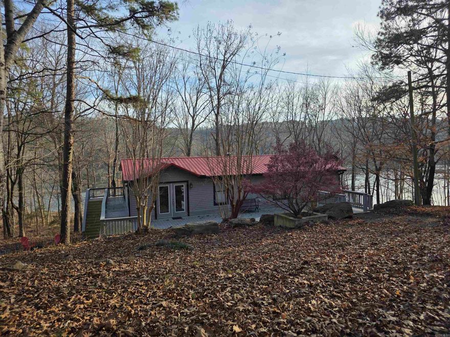 This lakefront opportunity does not come around often! Very very easy walk to the water from your back yard. Being able to have this view and easy walk is a very sought after thing around the Greers Ferry Lake area. Bring your clothes and toothbrush to this one and you are ready for your lake experience. All furnishings will stay to include bedding and even extra linens in every bedroom closet. Most artwork are one-of-a-kind pieces and bring a very tasteful decor to the home. There are 2 bedrooms on main level with one having an ensuite bath. Both bathrooms upstairs have jetted tubs. Downstairs you will find a kitchenette, open living space, and 2 more bedrooms and 1 bath. There are 5 outside doors downstairs. Each bedroom having their own door to outside. Safe room downstairs with access door from either inside or outside. Square footage measurement encouraged.