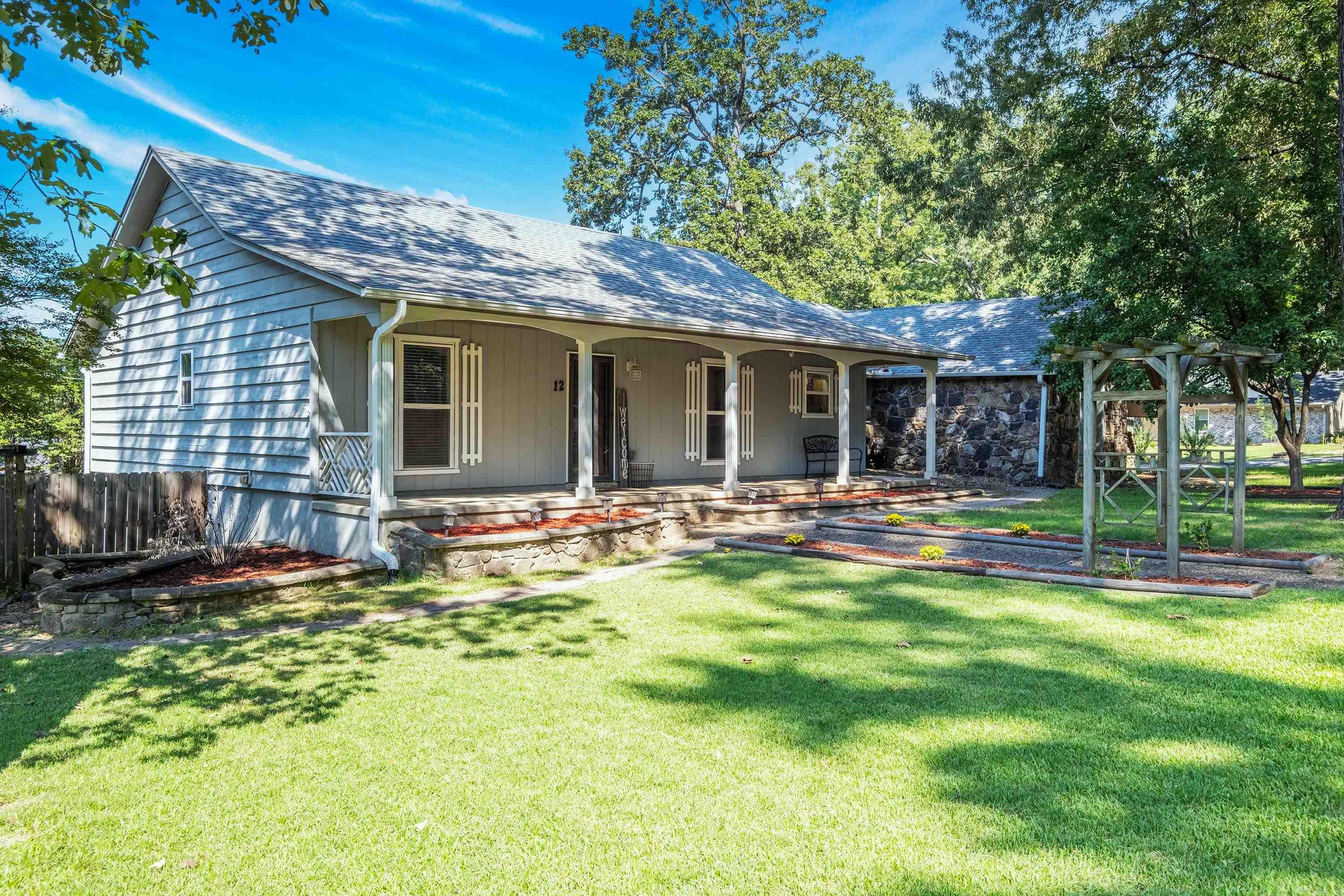 Adorable ranch-style home with a welcoming front porch and a spacious two-tiered deck across the backāperfect for entertaining! Situated on a large 0.35-acre corner lot in a beautiful established neighborhood with mature trees, this property offers both charm and convenience, just minutes from town.Step inside to find a huge living room with a cozy wood-burning fireplace, updated paint, and plenty of natural light. The split floor plan features 3 large bedrooms and 2 baths, including a spacious master suite with a walk-in closet, jetted tub, and updated closet doors.The oversized garage includes an extra storage room, plus a large storage building out back with WiFi, electricity, heating, and cooling. With tons of storage throughout, this home is move-in ready and checks all the boxes!