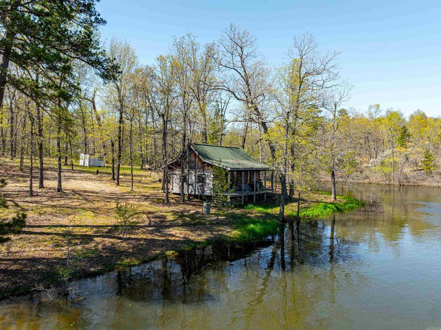 Discover true Ozark seclusion on this 116± acre property featuring a cedar log cabin overlooking its own private 3± acre lake. Located on the Izard/Fulton County line near Oxford, this off-grid retreat includes solar power, propane for cooking, water pumped from the lake, a full bathroom, kitchen, wood stove, and loft sleeping area. A gated entrance leads to a wooded drive with trails running throughout the property, connecting to established food plots, hunting areas, and natural springs. The land offers excellent habitat for deer, turkey, and bear, with several mature bucks harvested here. This is the perfect setup for a hunting cabin, weekend getaway, or off-grid living. Enjoy mature timber, privacy, and a picture-perfect cabin setting across the water. Shown by appointment only.
