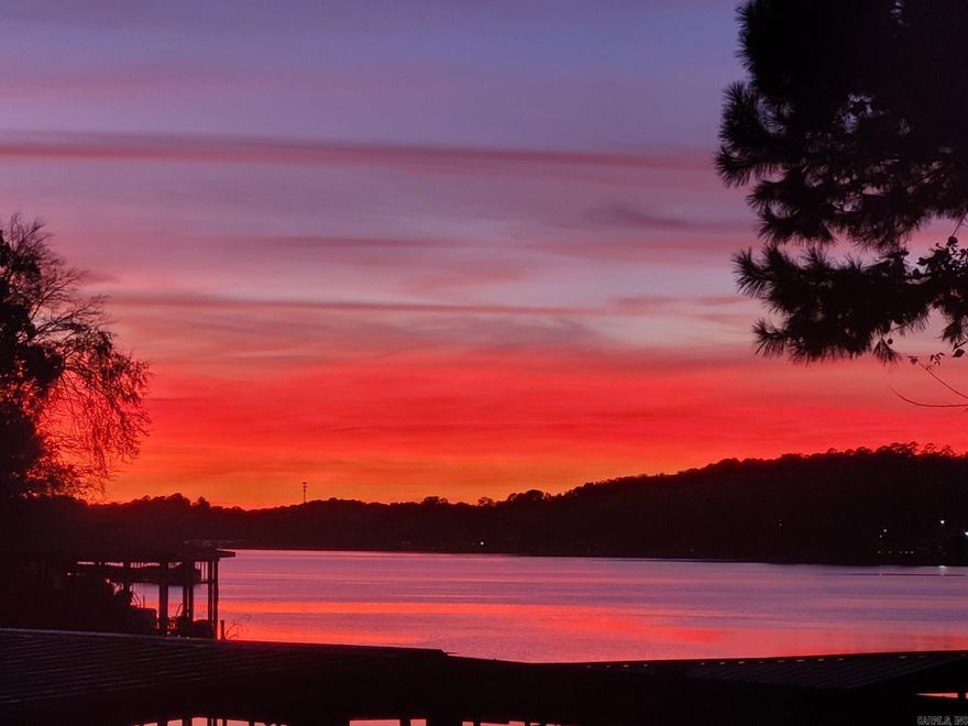 Imagine the sunsets you can witness from the decks of this beautifully maintained townhome! Your very own retreat on Lake Hamilton. Your private covered boat dock steps from your back deck. Location gives easy access to main channel. With an impressive Primary Suite, large windows providing natural light and lake views, and its own covered deck. It offers privacy for enjoying your morning coffee and sunrise.  Two additional bedrooms provide space for company. Large covered lower deck for entertaining.  Investors, also, need to check out this home-perfect for short or long term rental.