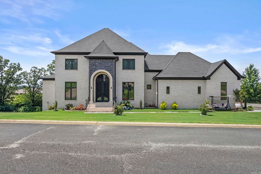 Say hello to your dream home at 18 River Ridge Rd in Searcy, AR, located in the desirable River Oaks Subdivision. This luxury home sits on a 0.54± acre lot and offers 7,465 sq ft of well-designed living space spread across three levels. The main floor features an open-concept living, dining, & kitchen area with an abundance of natural light, a gas log fireplace with tile surround, & an eat-in kitchen complete with two granite-topped islands, a walk-in pantry, & access to a spacious balcony with stunning views. The primary suite is a peaceful retreat with large, bay windows, private balcony access, a walk-in closet, & a tiled shower in the en suite bath. Main level also includes a large guest bedroom with a private en suite, separate half bath, laundry room, office & a three-car garage with golf cart storage. Upstairs, you’ll find a large open landing, two bedrooms with private en suites, two additional bedrooms connected by a Jack-and-Jill bathroom, & access to a balcony with breathtaking views. The basement offers even more living space with a second kitchen, living area, full bath, additional laundry room, & 2 storage/flex rooms. This home truly has it all! Call today for a tour!